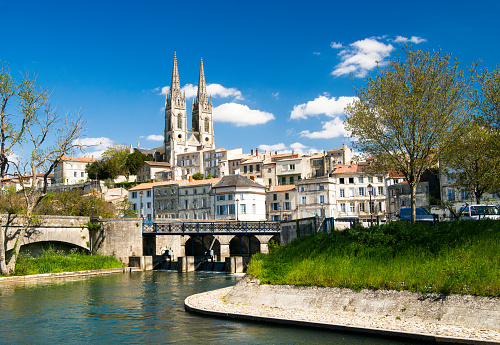 Saint Andrew's Church, old city of Niort and river. Photograph taken on a sunny day from the river banks