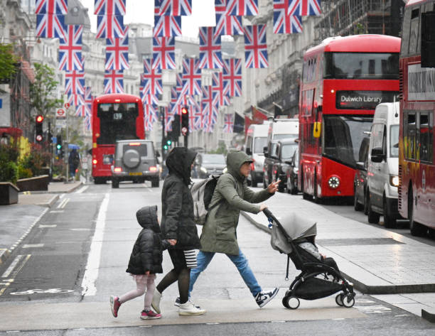 Typical English weather with a family battling through rain and London traffic. Regent Street, London, UK