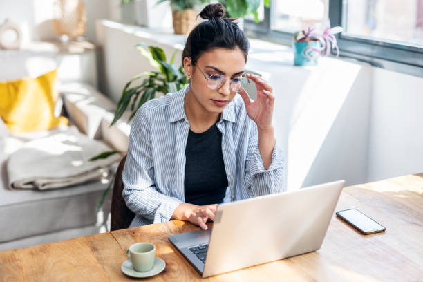 istock Beautiful attractive entrepreneur woman working with laptop while drinking coffee in the living room at home. 1486836631