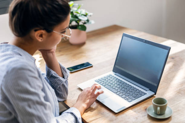 istock Beautiful attractive entrepreneur woman working with laptop while drinking coffee in the living room at home. 1486836642
