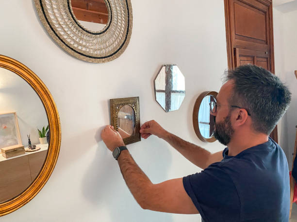 istock Man hanging mirrors in the hall at home 1486836758