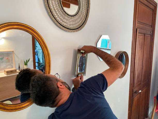 istock Man hanging mirrors in the hall at home 1486836777