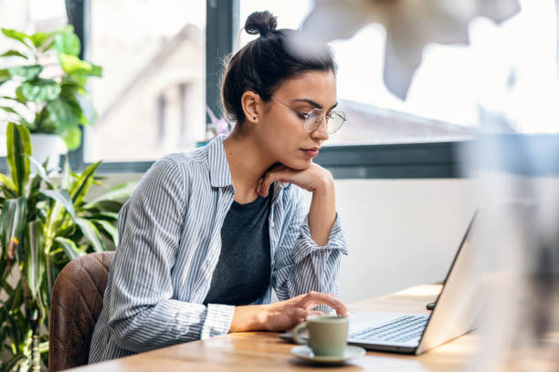 istock Beautiful attractive entrepreneur woman working with laptop while drinking coffee in the living room at home. 1486838721
