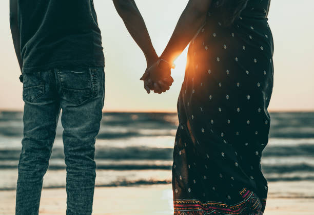 istock couple holding hand on the beach at sunset 1486844426