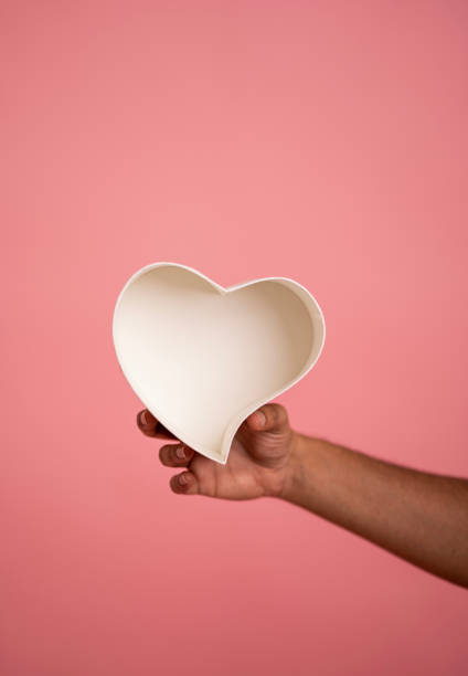 istock Holding Heart shape empty gift box isolated on pink colour 1486845917