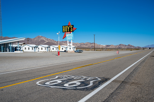 Amboy, California - January 23, 2023: A Route 66 icon painted in the highway at Amboy, California with Roy's Motel in the background.