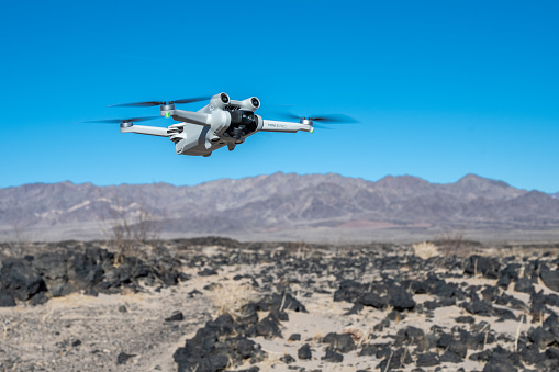 Amboy, California - January 27, 2023: A DJI Mini 3 Pro drone quadcopter hovers above a desert landscape in the Mojave Desert.