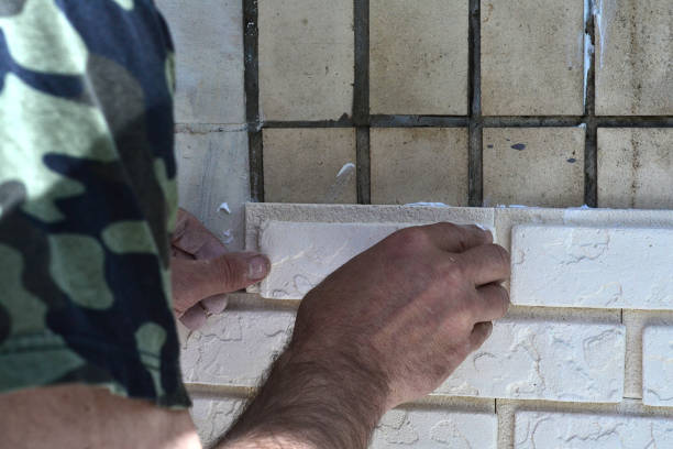 istock A man lays light tiles on an old balcony wall 1486852537