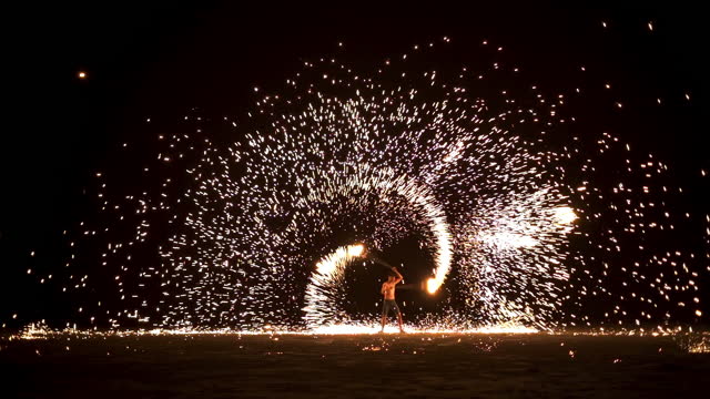 Stunning fire swing show on the beach night in Thailand, slow motion footage fire show.