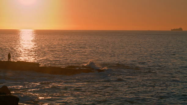 istock Human silhouette watching sunrise at ocean. Ferry sailing dawn tranquil water 1486853919