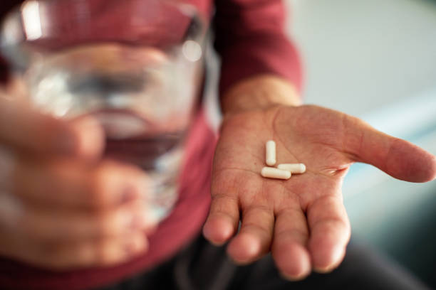 istock Senior man taking a pill in a bathroom 1486854282