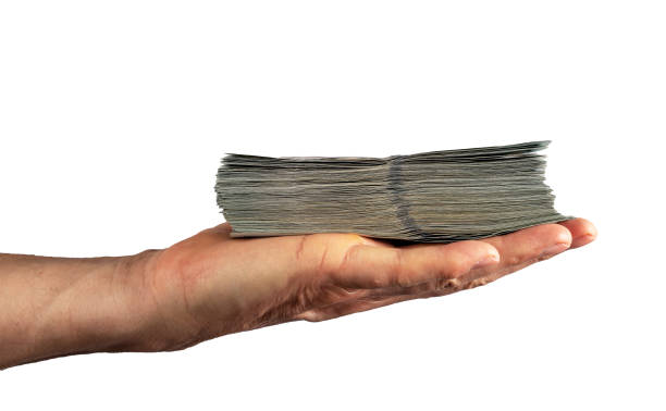 istock Hand palm holding dollars money stack, bank notes isolated on white background 1486857104