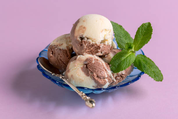 Homemade chocolate-vanilla ice cream is served with fresh mint, selective focus. Copy space. Concept of summer desserts.