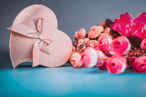 Golden colour gift box with beautiful flowers on the background