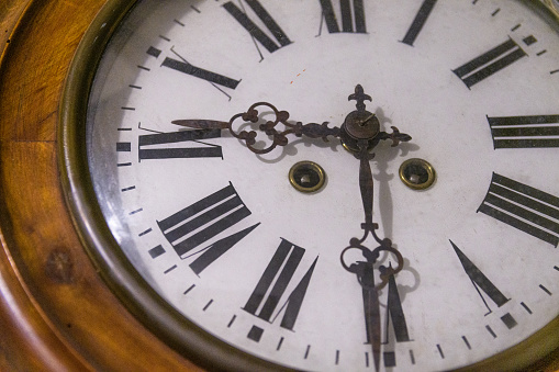 Sepia toned image of an old clock face isolated on a white background