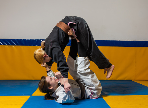 Young girls practice Brazilian jiu jitsu in the gym