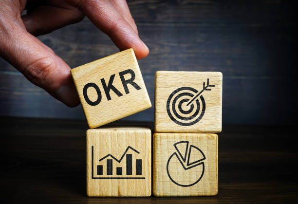 The hand holds the cube next to the others. OKR Objectives and Key Results. stock photo