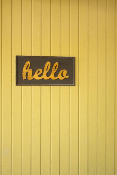 istock Vibrant yellow beadboard wall with a cheerful hello greeting sign displayed prominently 1486871259