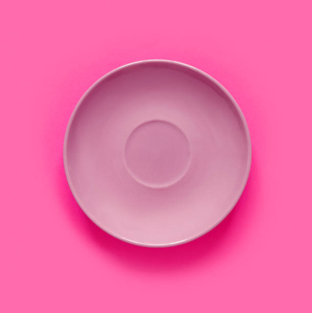 istock Pink plates on pink table. Monochrome minimalistic image in hipster style. 1486878371