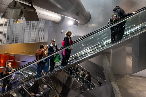 Naples, Italy - April 21, 2023: In the Garibaldi station of the Metro line 1 people enter and exit using the many escalators.