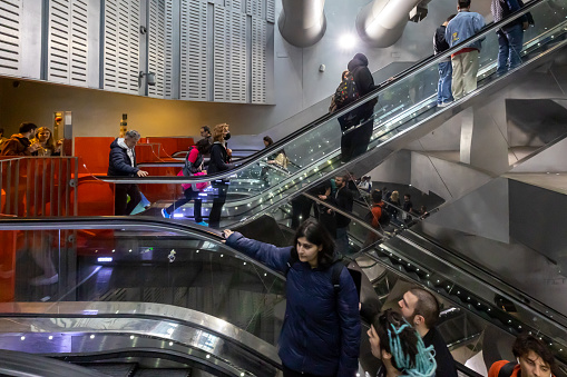 Naples, Italy - April 21, 2023: In the Garibaldi station of the Metro line 1 people enter and exit using the many escalators.