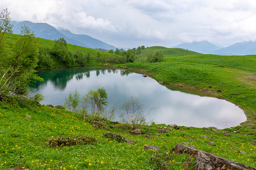 view of the mountain lake of love in the shape of a heart near Arkhyz, the photo was taken on a cloudy summer day