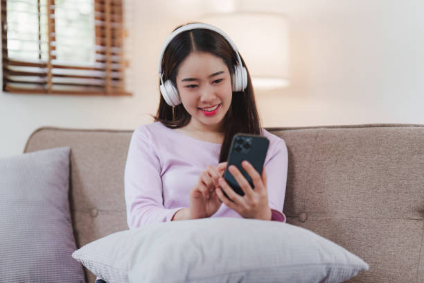 istock Attractive Asian woman resting comfortable living room and using mobile phone, Relax, Sofa, Lifestyle 1486879258