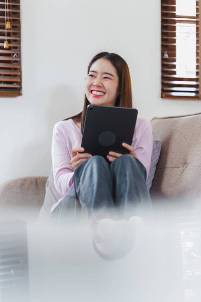 istock Attractive Asian woman resting comfortable living room and using digital tablet, Relax, Sofa, Lifestyle 1486879516