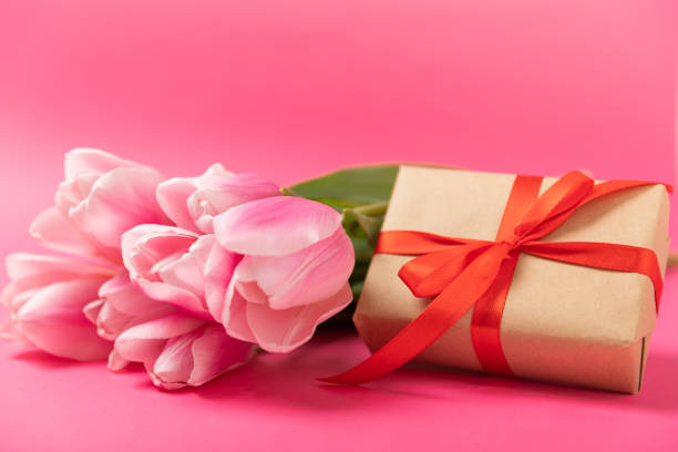 istock Pink tulips and a gift box on a pink background. Side view. Spring bouquet. Holiday concept. Women's Day, Valentine's Day, Easter, birthday. Copy space. 1486881045