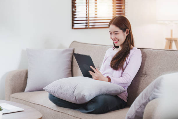 istock Attractive Asian woman resting comfortable living room and using digital tablet, Relax, Sofa, Lifestyle 1486882548