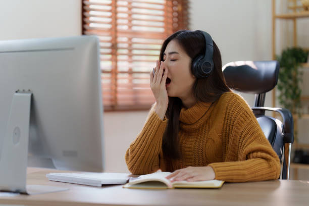 istock Online education, e-learning. Asian woman relaxing after studying using a laptop, listening to online lecture, taking notes, online study at home 1486883078
