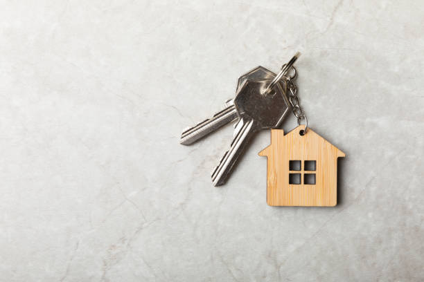 clés de maison avec un porte-clés en forme de maison. composition sur fond de marbre gris. élément de conception. concept immobilier et d’assurance. place pour la copie. - clé de maison photos et images de collection