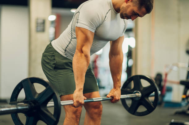 istock A strong bodybuilder is bending and lifting weights in a gym. 1486887851
