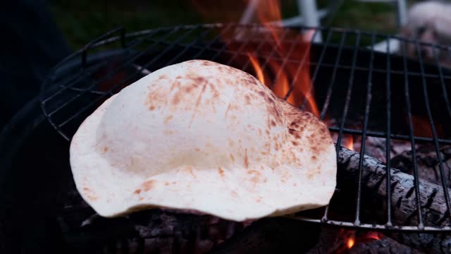 Pita cooking on charcoal. Bread on the grill.