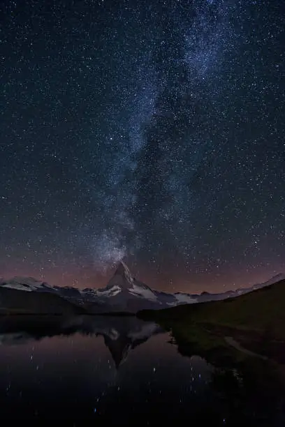 View of Lake stellisse at night with Milky way over Matterhorn - Switzerland