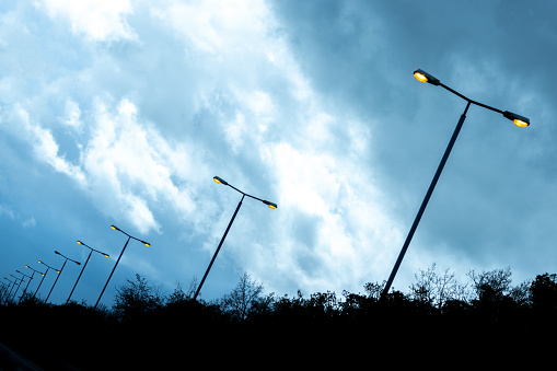 A series of street lights leading away from shot lighting the way along a carriageway or motorway route.