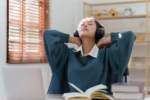 istock Online education, e-learning. Asian woman relaxing after studying using a laptop, listening to online lecture, taking notes, online study at home 1486892652