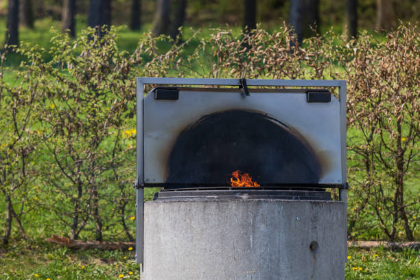 Solid concrete fireplace for outdoor grilling. He's warming himself in the fireplace.