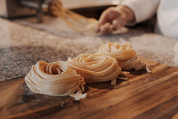istock Delicious raw rolled tagliatelle pasta on wooden cutting board 1486894528