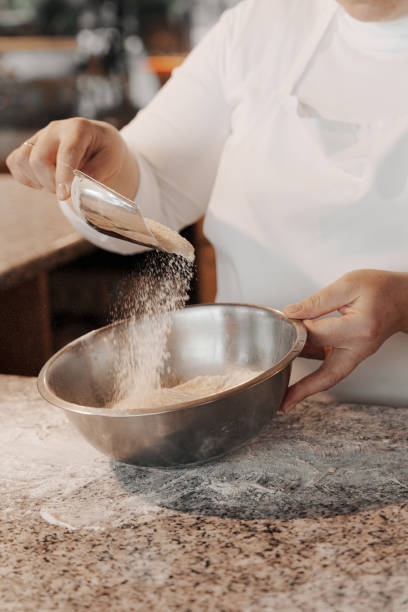 istock Crop woman adding flour into bowl 1486894566