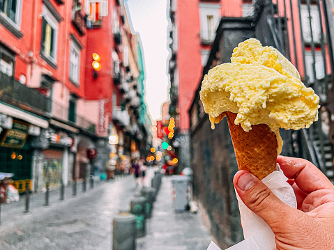 Young Man’s Hand Holding a Vibrant Yellow Lemon-Flavored Italian Gelato Ice Cream in the Centro Storico Neighborhood