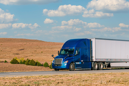 Driver's Point of View of an American Conventional Cab-Forward Semi Truck Driving on Interstate 70 across the Plains of Kansas on a Sunny Day