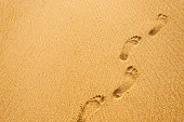 Footprints in the sand at sunset time