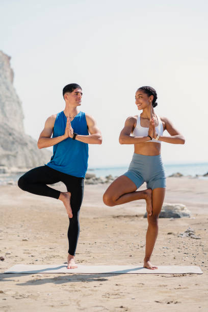 istock Young couple doing exercise together on the beach 1486899797