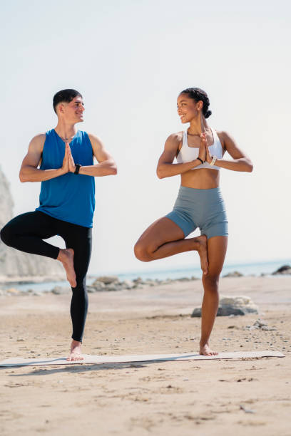 istock Young couple doing exercise together on the beach 1486900412