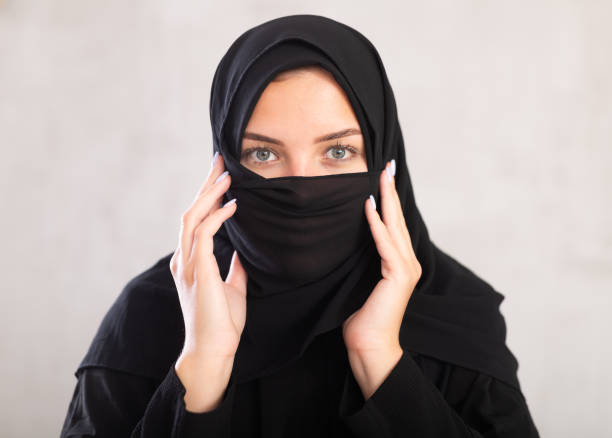 Muslim woman with face covered with burka holds thin fabric of yashmak with her hands young light-skinned Muslim woman with kind eyes and face covered with burka holds thin fabric of yashmak with her hands azerbaijani culture stock pictures, royalty-free photos & images