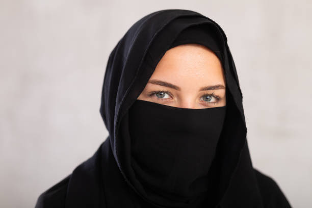 Muslim woman with face covered with burka holds thin fabric of yashmak with her hands young light-skinned Muslim woman with kind eyes and face covered with burka holds thin fabric of yashmak with her hands azerbaijani culture stock pictures, royalty-free photos & images