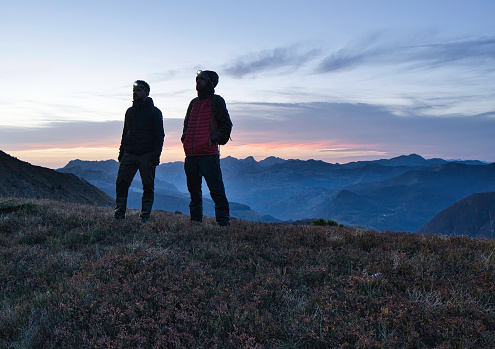 A silhouette of mountaineers against the sunset