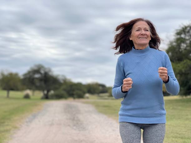Senior woman running outdoors stock photo