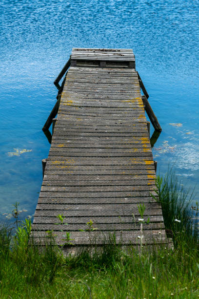 Wooden jetty on blue water stock photo